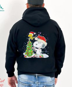 Snoopy and Woodstock wear Santa hats by the pine tree Christmas shirt