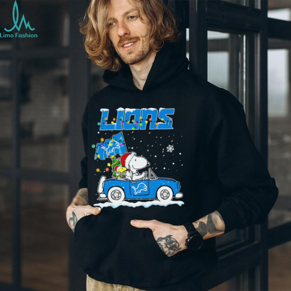 Happy Merry Christmas Snoopy drive a car Detroit Lions logo flag gift shirt Happy Merry Christmas Snoopy drive a car Detroit Lions logo flag gift shirt