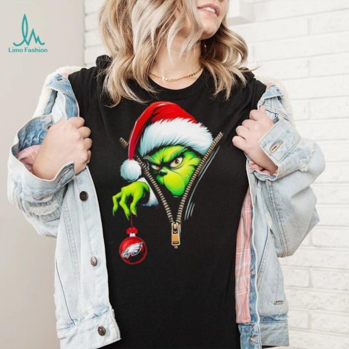 Santa Grinch insdie zipper holding Philadelphia Eagles shirt
