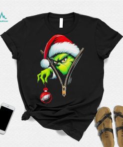 Santa Grinch insdie zipper holding Philadelphia Eagles shirt