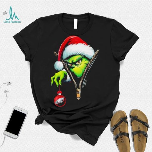 Santa Grinch insdie zipper holding Philadelphia Eagles shirt