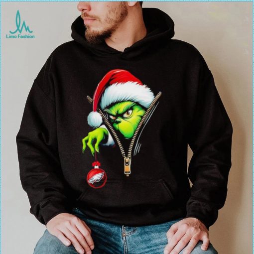 Santa Grinch insdie zipper holding Philadelphia Eagles shirt