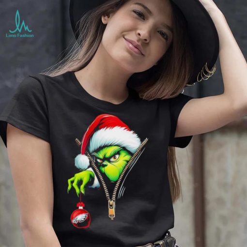 Santa Grinch insdie zipper holding Philadelphia Eagles shirt