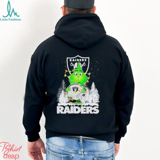 The Baby Grinch hugging Las Vegas Raiders helmet snowy forest Christmas shirt