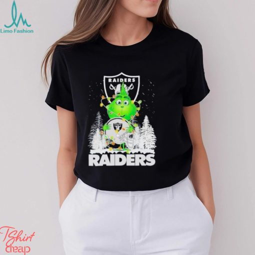 The Baby Grinch hugging Las Vegas Raiders helmet snowy forest Christmas shirt