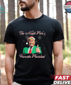 Trump The North Pole’s Favorite President Christmas T-shirts featuring a festive design with a playful message, "The North Pole’s Favorite President," making it a fun and lighthearted way to combine holiday cheer with political humor. Perfect for those who enjoy celebrating Christmas with a bit of political flair.